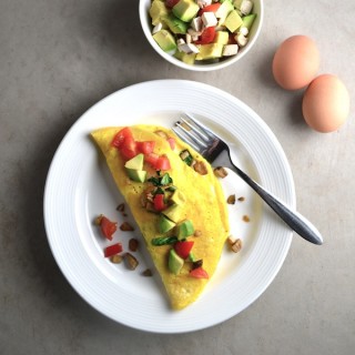 Veggie Omelet - This omelet recipe is packed with tasty vegetables like onions, mushroom, spinach, and tomatoes. Top with avocados and cheese for a quick and delicious breakfast. | twothirdscup.com